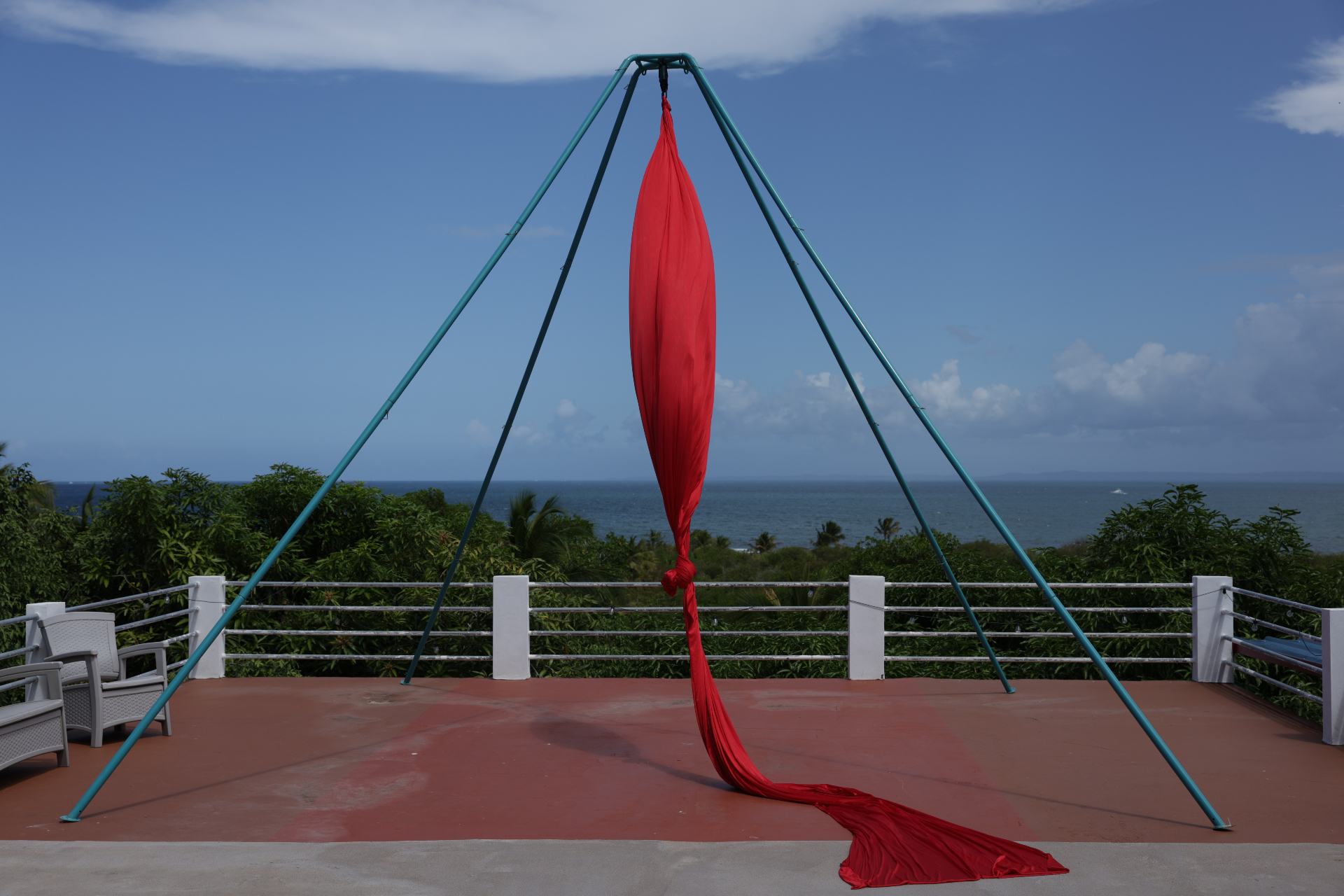 Red aerial silks rig set up outdoors by the ocean in Puerto Rico for a WINGS confidence-building retreat